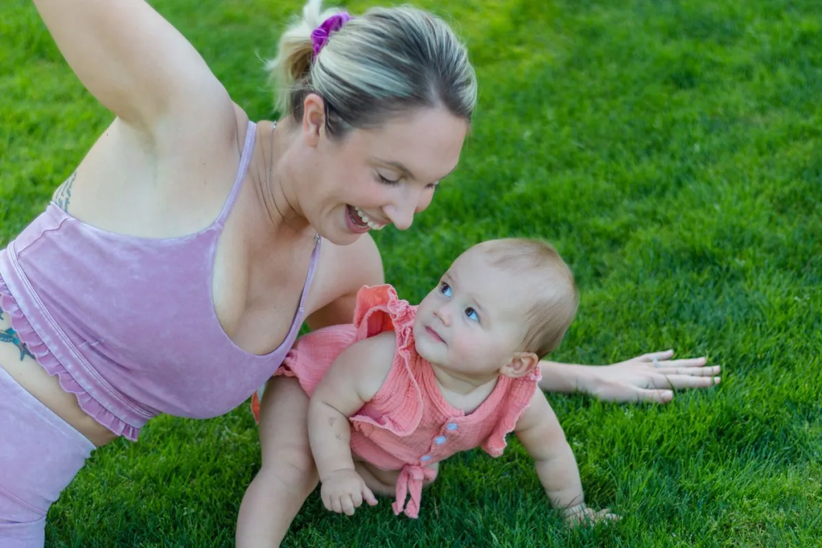 Una mamma si muove sull'erba accanto alla sua bambina